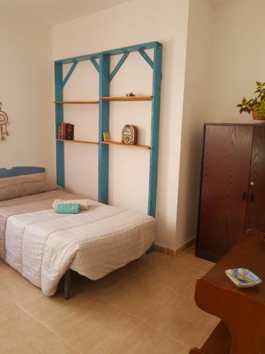a bedroom with a bed and a shelf on the wall at Laurainu in Puerto del Rosario