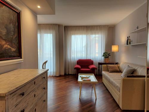 a living room with a couch and a red chair at Trilocale Ferruccio in Baveno