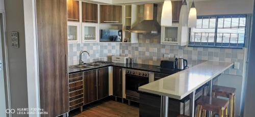 a kitchen with a sink and a counter top at Whale Rock 29, The ultimate beach living experience. in Margate