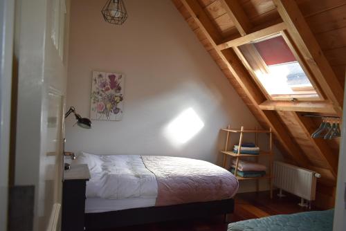a bedroom with a bed in a attic at B&B De Pastorie bij Dokkum in Reitsum