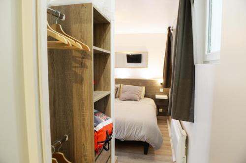 a small room with a bed and a closet at O2 Horizon in Le Tréport