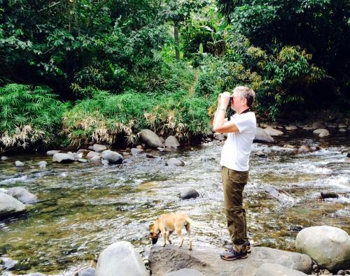 a man taking a picture of a river with a dog at Hibiscus Valley Inn in Marigot