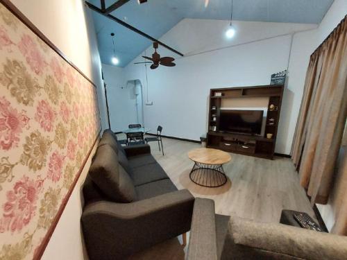 a living room with a couch and a tv at Ren-Hana Kundasang in Kundasang