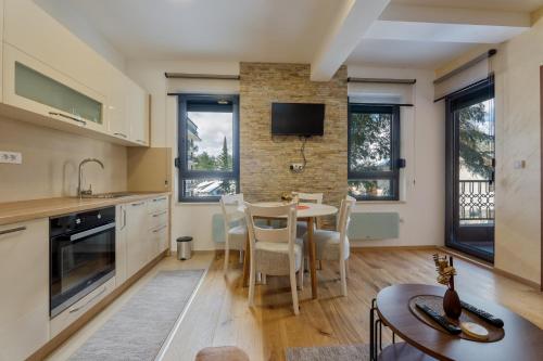 a kitchen and dining room with a table and chairs at Villa Bella Apartman 12 in Zlatibor