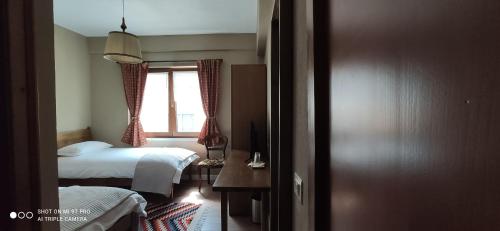 a bedroom with two beds and a window at Guesthouse Tershana in Peshkopi