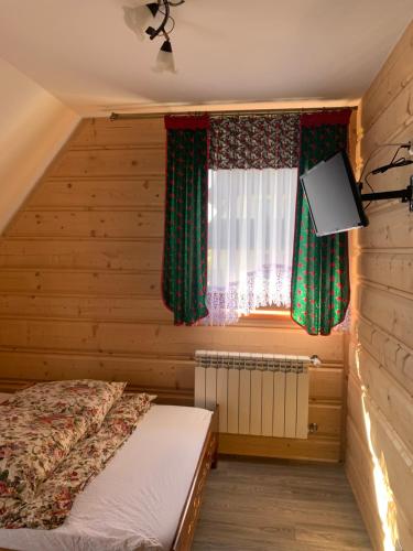 um quarto com uma cama e uma janela em Domki Magdalena przy termach chochołowskich em Witów