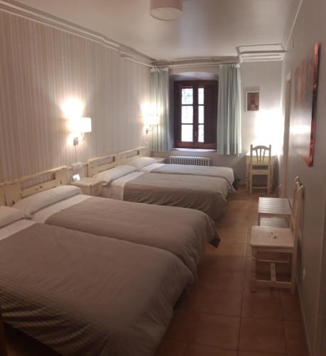 a row of beds in a room with lights at MONASTERIO de SANTA MARÍA DE VALVANERA in Anguiano