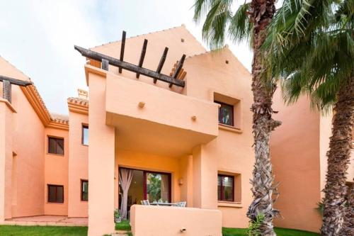 a house with palm trees in front of it at Lovely and luxury apartament in front of the beach in Los Alcázares