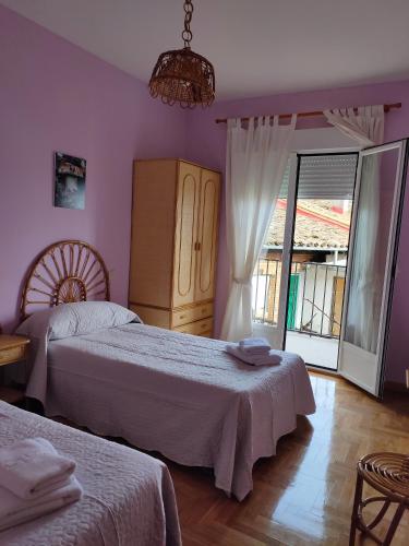a bedroom with two beds and a window at Casa Rubén Darío in Villarejo del Valle