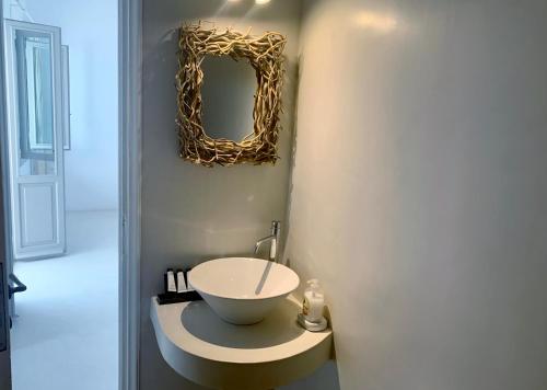 a bathroom with a sink and a mirror on the wall at SORINA Beloved Rooms in Spetses