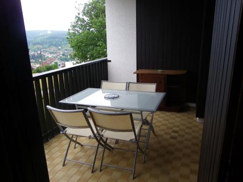 d'une table blanche et de deux chaises sur un balcon. dans l'établissement f2 gerardmer, à Gérardmer