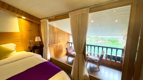 a bedroom with a balcony with a bed and a window at Bian Cheng Xing Zi Inn in Fenghuang