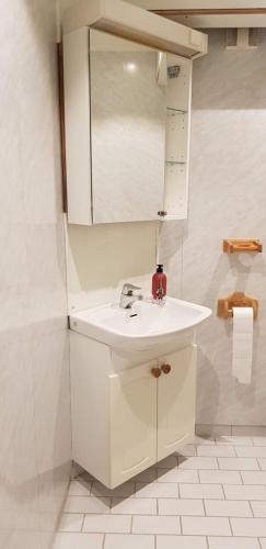 ein Badezimmer mit einem weißen Waschbecken und einem Spiegel in der Unterkunft Dallavaraveien 4 in Vadsø