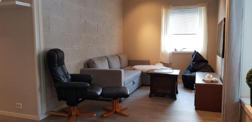een woonkamer met een bank en een stoel bij Dallavaraveien 4 in Vadsø