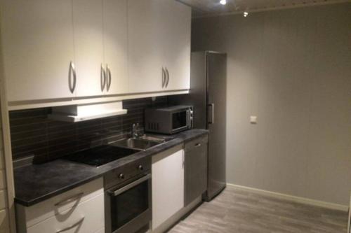 a kitchen with a sink and a microwave at Dallavaraveien 4 in Vadsø