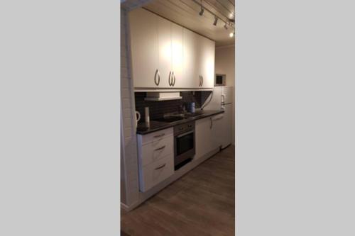 a kitchen with white cabinets and a stove at Dallavaraveien 4 in Vadsø