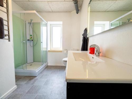 y baño con lavabo y ducha. en Købmandsgårdens B&B, en Saeby