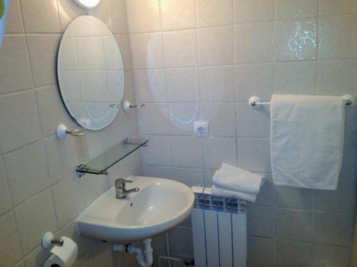 a white bathroom with a sink and a mirror at Hostal Alce in Playa de Palma