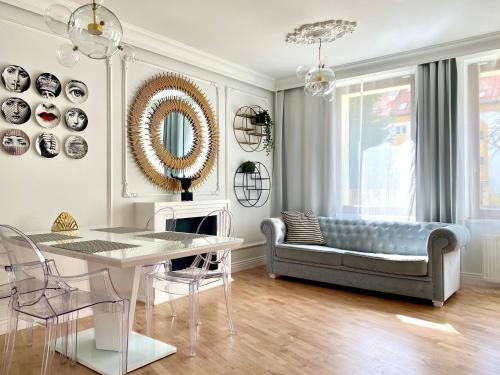 a living room with a couch and a table at Apartament Gold 300 m do Plaży - Praia Apartments Sopot in Sopot