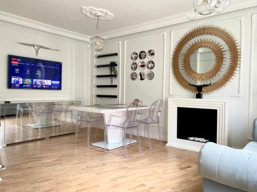 a living room with a table and a fireplace at Apartament Gold 300 m do Plaży - Praia Apartments Sopot in Sopot