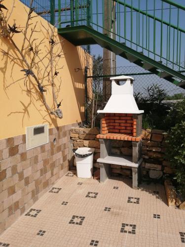a brick patio with a brick oven next to a staircase at Varandas da Serra II in Vila Franca de Xira