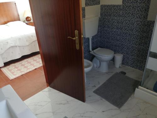 a bathroom with a toilet and a bed at Varandas da Serra II in Vila Franca de Xira