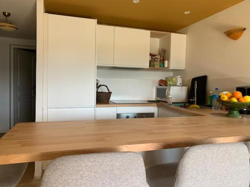 uma cozinha com uma mesa de madeira e 2 cadeiras em Domaine Sesquier Mas d'exception Hibiscus em Mèze