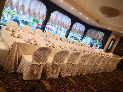 a long table with white chairs and a long table at Hotel Columbus sul Lago in Bolsena