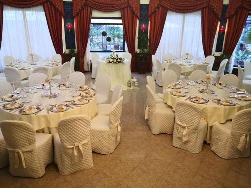 a room filled with tables and chairs with white tablecloths at Hotel Columbus sul Lago in Bolsena