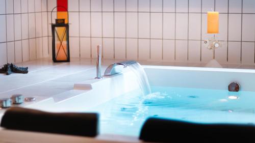 uma banheira com uma fonte de água em Park - Hotel Inseli em Romanshorn