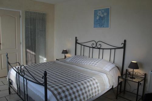 a bedroom with a bed with a black and white comforter at Chambres d'hôtes La Prairie in Belley
