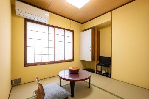 a room with a table and a window at 素泊まり宿　瑞宝荘 in Atami
