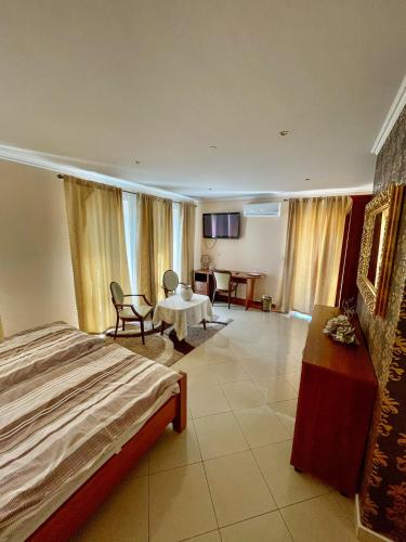 a hotel room with a bed and a table and chairs at Penzion Vegas in Partizánske