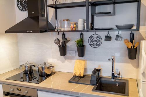 a kitchen with a sink and a stove with utensils at Les appartements Privés Bar in Bar