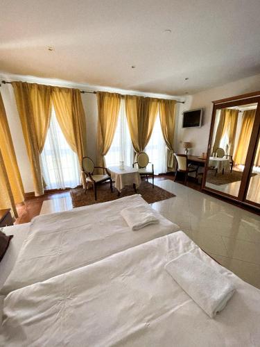 a large white bed in a room with windows at Penzion Vegas in Partizánske
