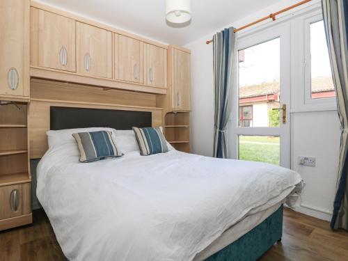 a bedroom with a large white bed and a window at Miles Retreat in Hayle