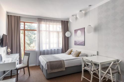 Habitación de hotel con cama, mesa y sillas en Delight Deluxe Hotel & Spa en Antalya