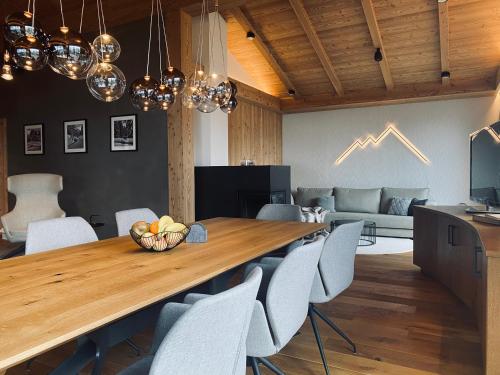 una cucina e un soggiorno con un grande tavolo e sedie in legno di Florisa Mountain Penthouse a San Vigilio Di Marebbe