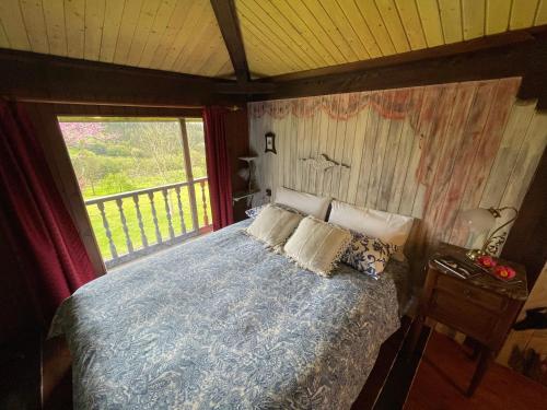 a bedroom with a bed and a large window at Son de Mar Hotel rural & Apartamento in Quintueles