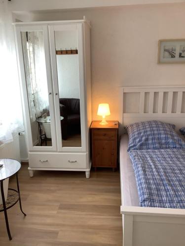 a bedroom with a bed and a dresser with a mirror at Pension Villa Wolkenlos in Dahme