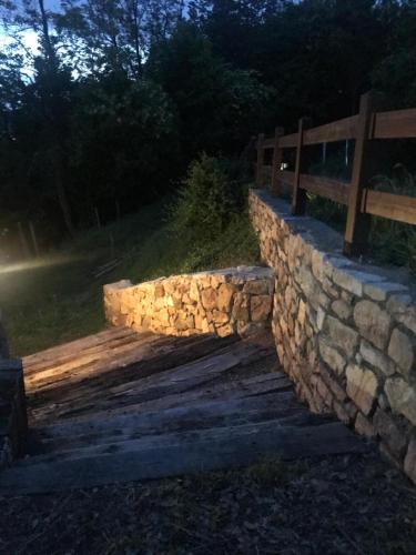 a stone retaining wall with a wooden bridge at LE LANTERNE in Villa dʼAlmè