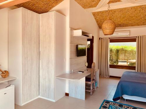 a bedroom with a bed and a desk in a room at Villa Ferradura Mar in Búzios