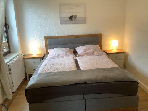 a bed in a bedroom with two lamps on tables at Pension Villa Wolkenlos in Dahme