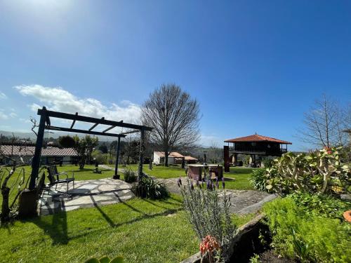 a garden with a wooden structure in the grass at Son de Mar Hotel rural & Apartamento in Quintueles