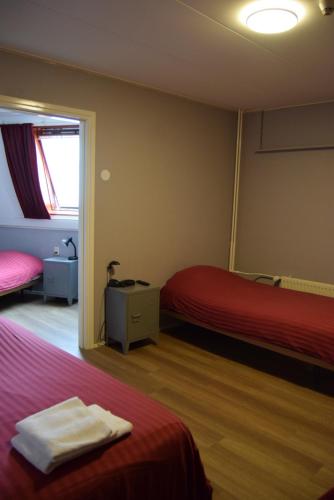 a hotel room with two beds and a window at Hotel Cafe 't Zonneke in Oosterhout