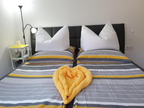 two beds with a heart shaped towel on them at Golf & Ski Appartements Mittersill Trausmuth Monika inkl Sommercard - Golfplatz 500 m entfernt, inkl Waschmaschine, Trockner in Mittersill