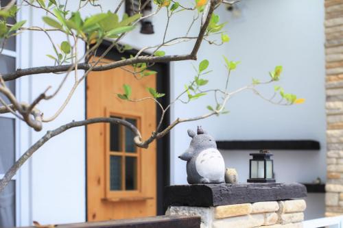 a statue of a rat sitting on a wall in front of a house at 白鹿詩行旅 in Tainan