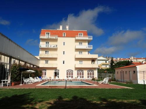 - un grand bâtiment blanc avec une piscine en face dans l'établissement Hotel Caldas Internacional, à Caldas da Rainha