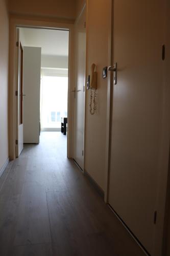 an empty hallway with an open door and a hallwayngthngthngthngthngthngth at Studio Belle Vue in Koksijde