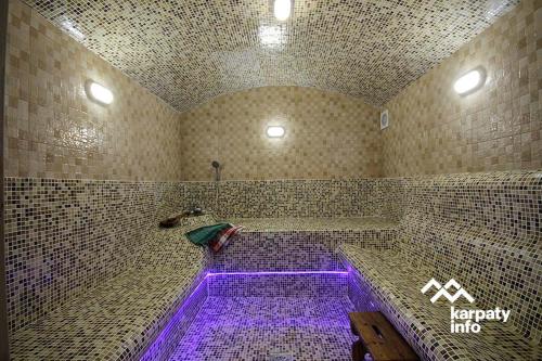 een badkamer met een bad met paarse verlichting. bij Хамам Вілла Даросо з басейном in Kosiv